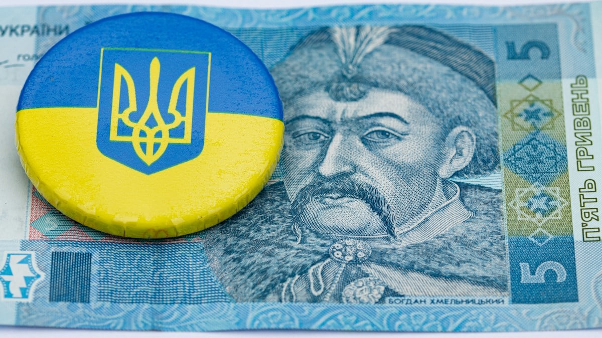 a blue and yellow button sitting on top of a money bill